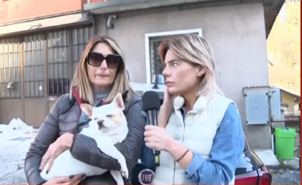 La volontaria con la cagnolina Bianca davanti all'abitazione di Strozza